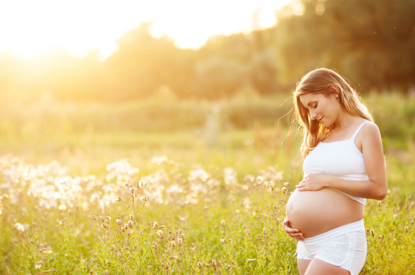 Beautiful pregnant woman relaxing outside in the park